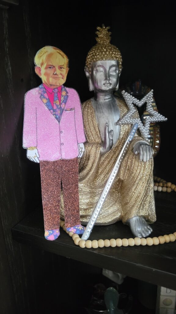 paper doll next to buddha with a star wand