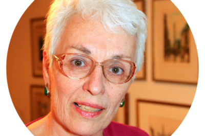 Elderly woman with glasses and white hair.