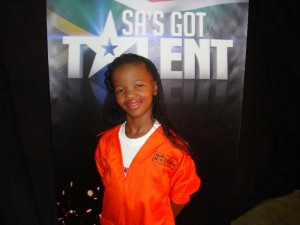 Child smiling at talent show event.