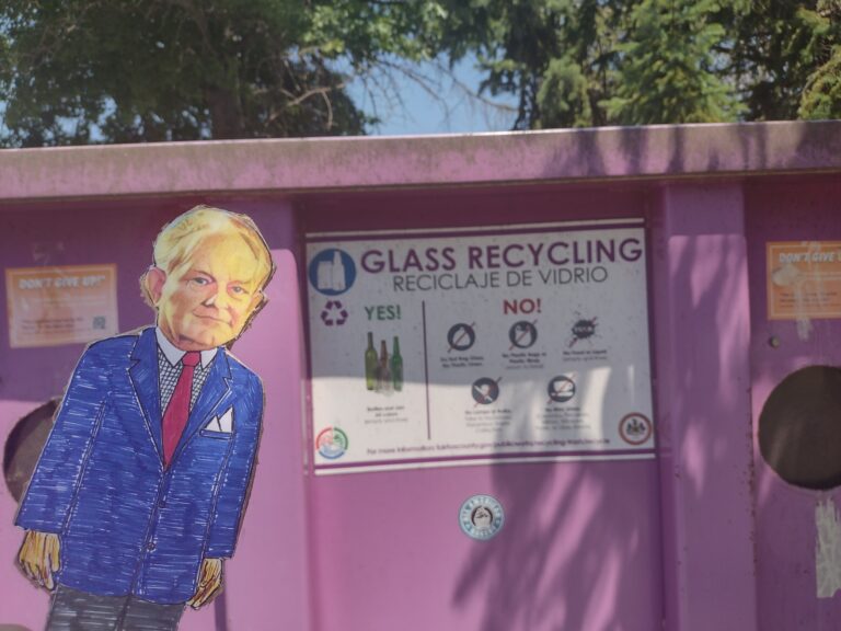 paper doll in front of glass recycling box