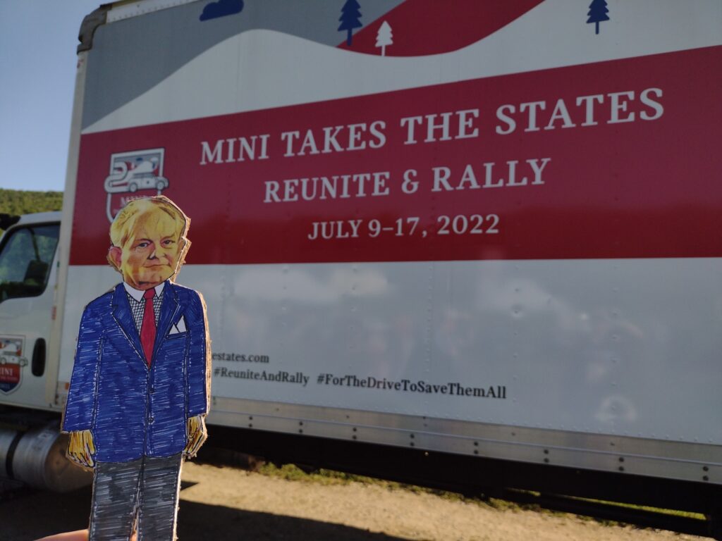 paper doll in front of a truck with mini takes the states