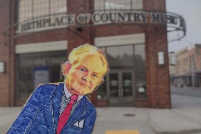 paper doll in front of brick building birthplace of country music