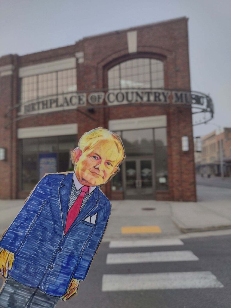 paper doll in front of brick building birthplace of country music