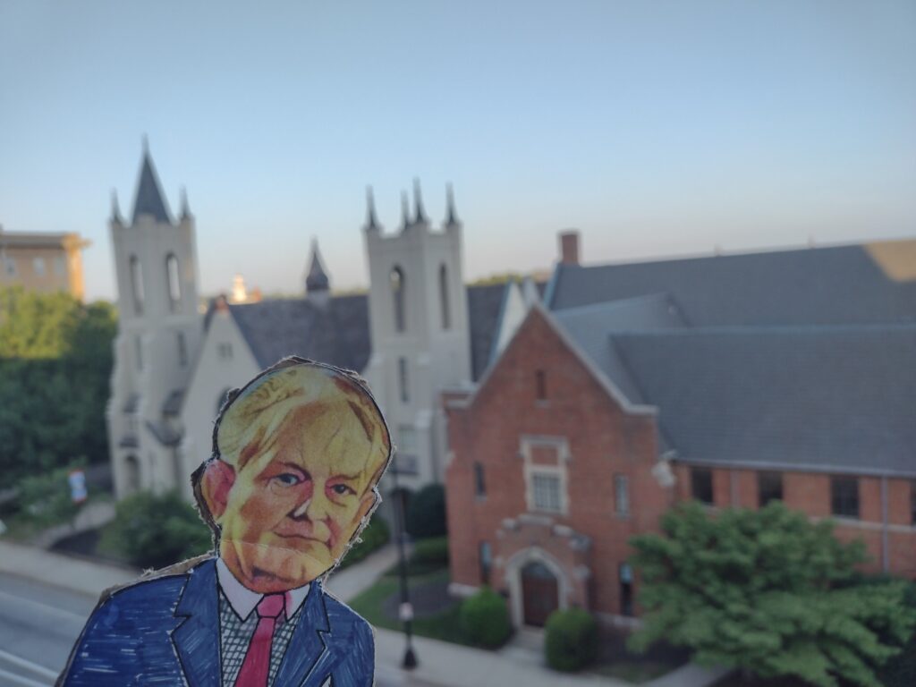 paper doll in front of cathedral and blue sky