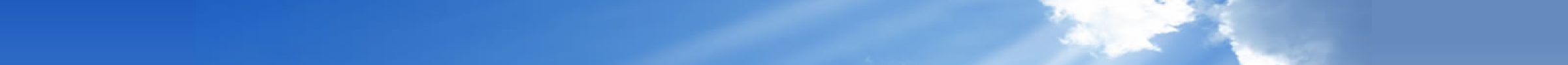 Clear blue sky with soft white clouds and sun rays.