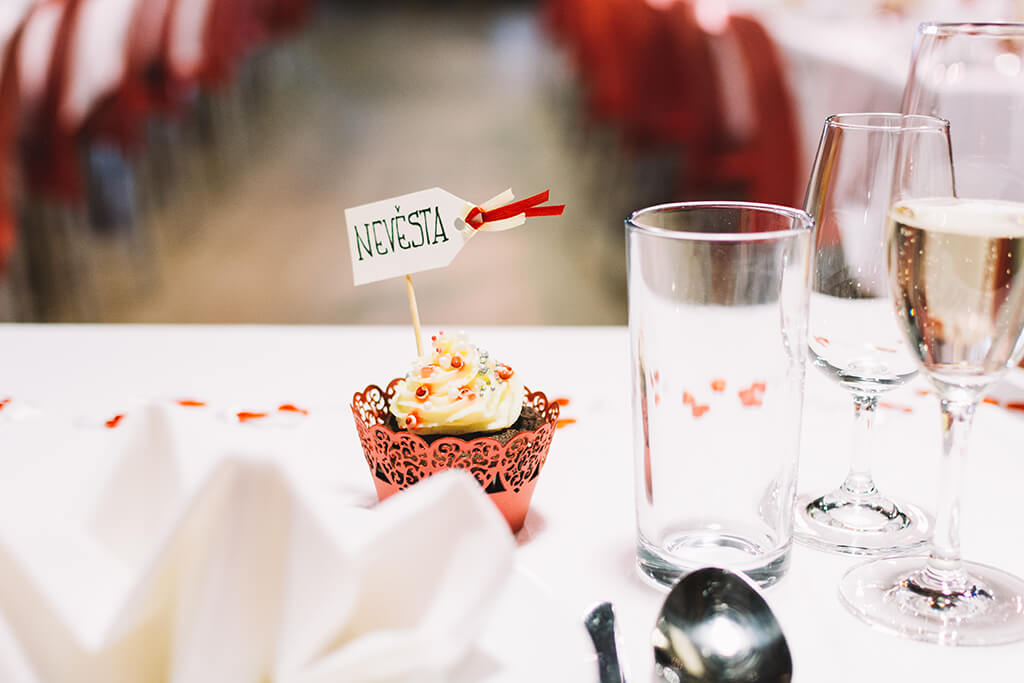 A cupcake with a name tag 'Nastia' and a glass on a table.