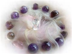 Amethyst stones arranged in a circle with a central clear crystal and misty smoke effect.