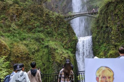 paper doll in front of a waterfall