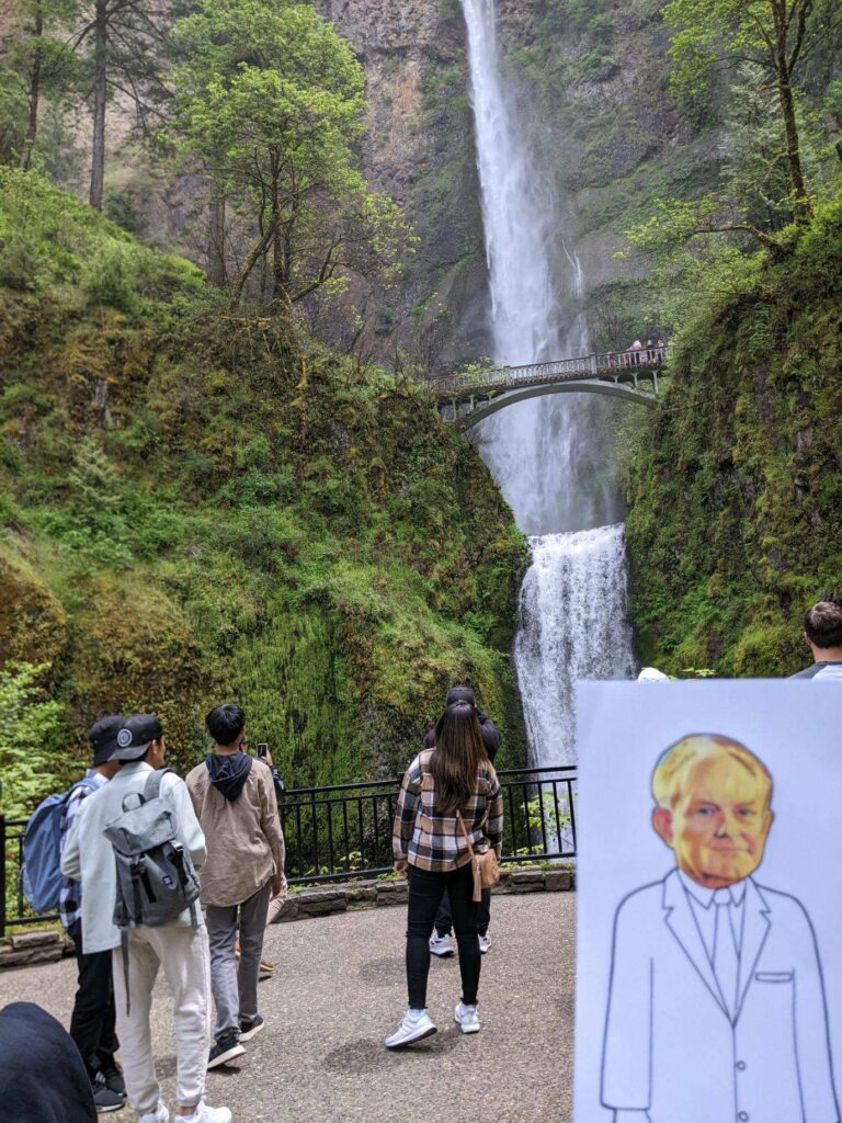 paper doll in front of a waterfall