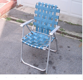 A blue woven strap lawn chair on pavement.