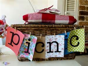 Picnic basket with colorful 'picnic' banner and wrapped items on top.