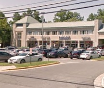 Shopping center with parked cars outside.