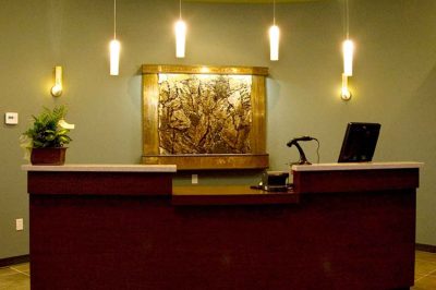 Reception desk with warm lighting and decorative art.